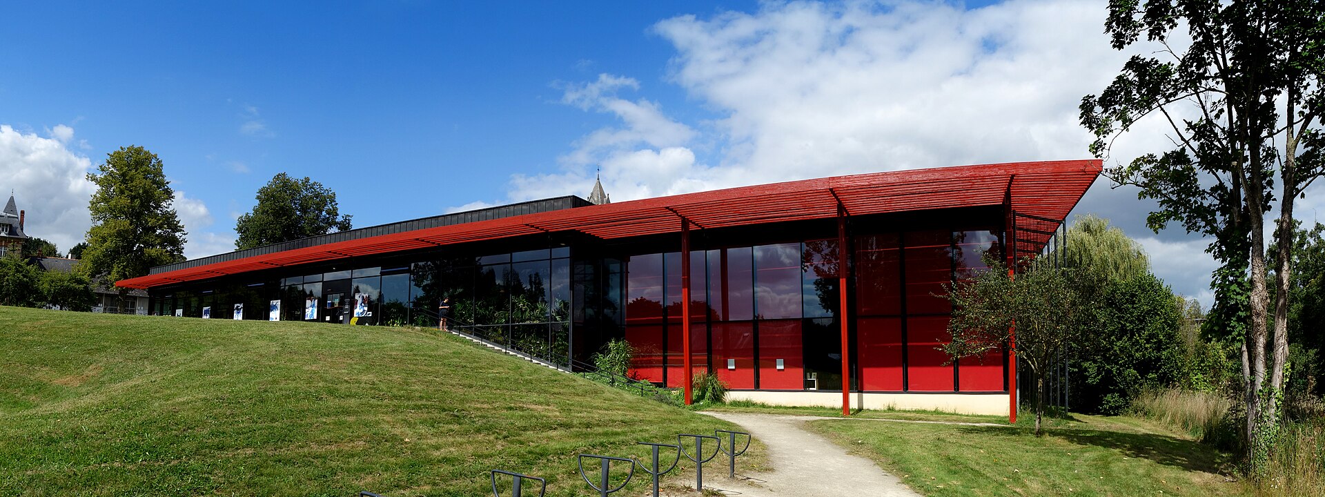 La médiathèque municipale, un bâtiment bas en verre sous un auvent rouge